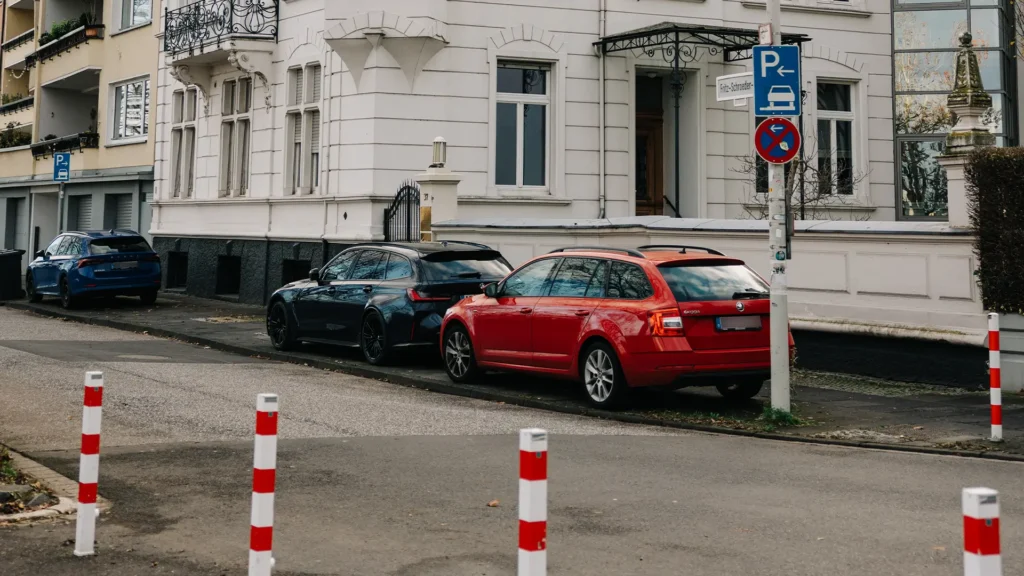 Straßenansicht eines historischen Kanzleigebäudes mit parkenden Autos am Straßenrand.